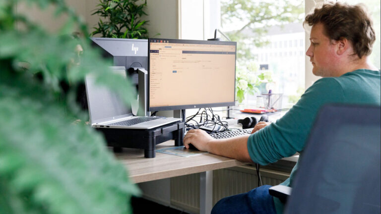 Medewerker werkt aan een computer